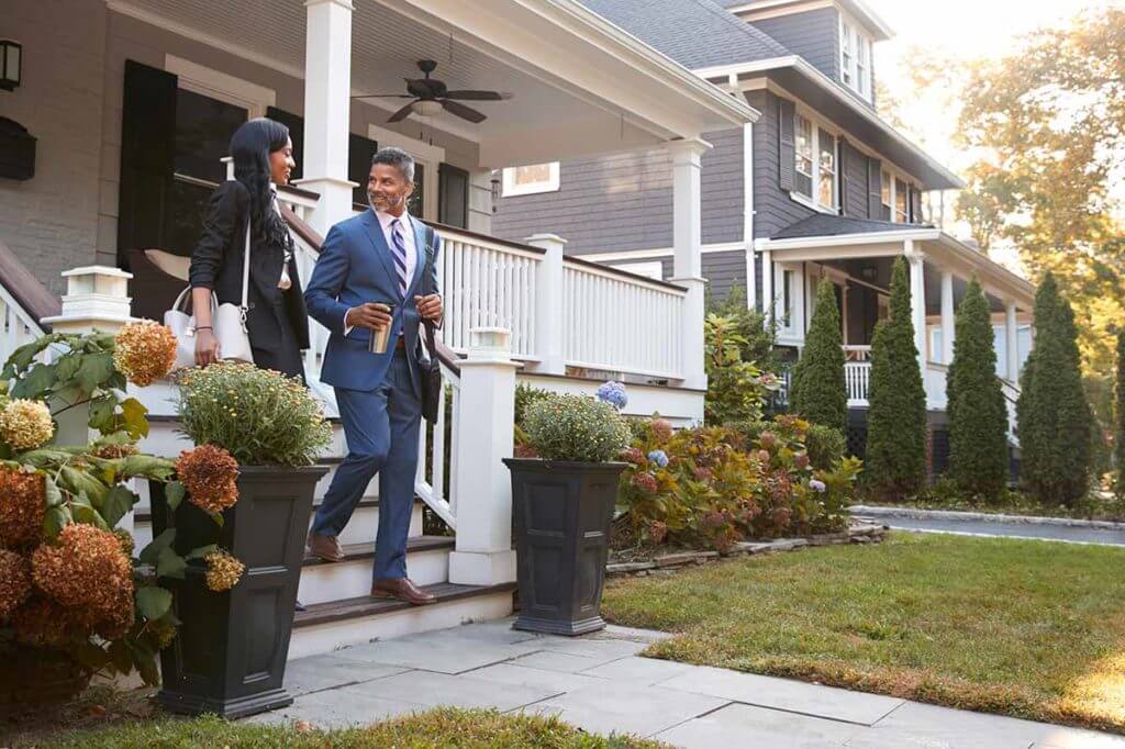 Man and woman walking out of their house